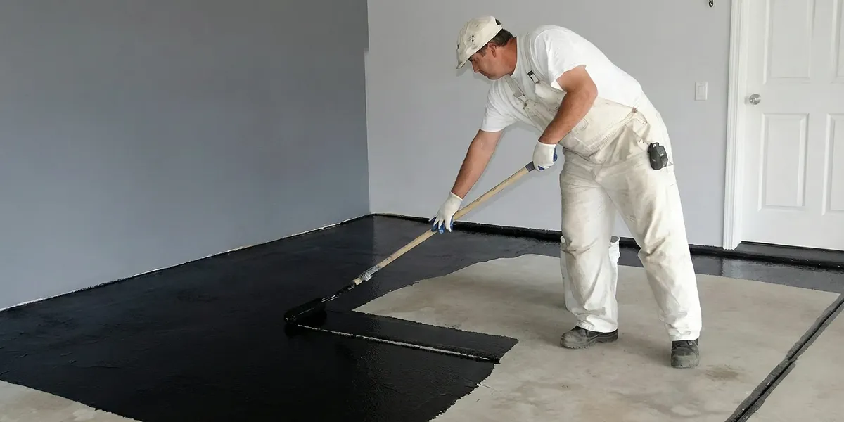 basement waterproofing professional applying waterproof coating to protect a basement floor in Miami, FL